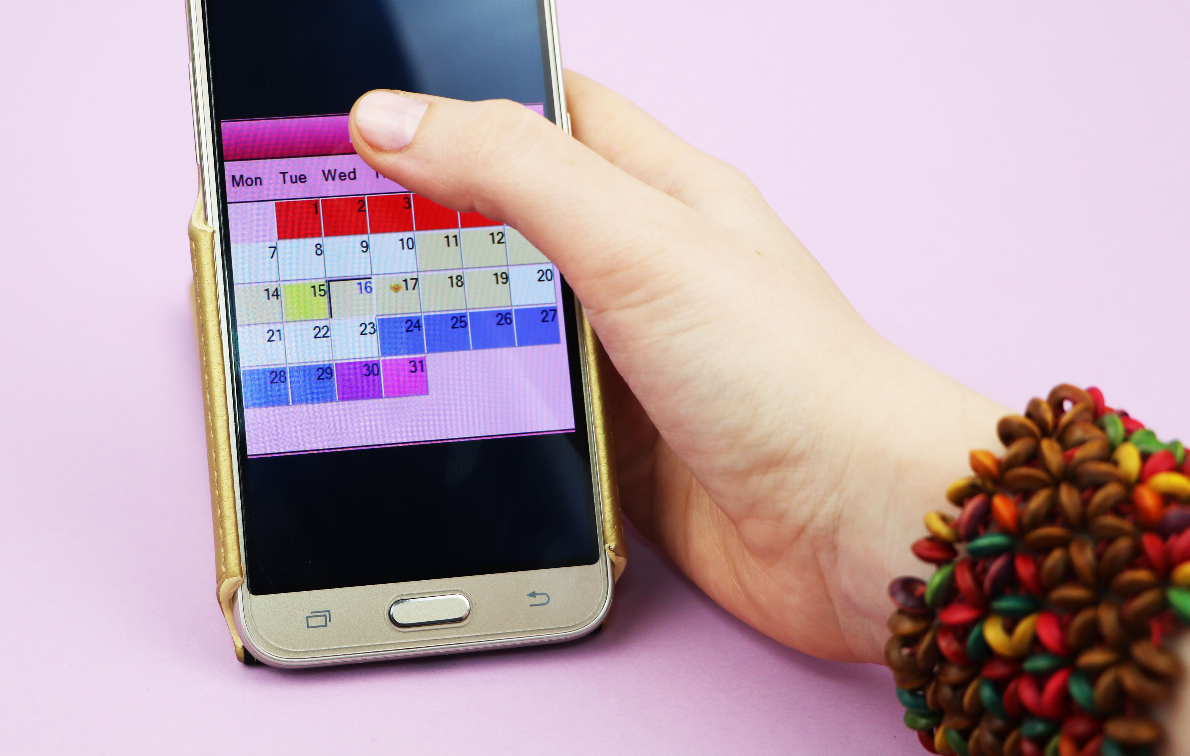 Smartphone showing a time-blocking calendar app with colour blocks representing daily schedule on a soft grey background